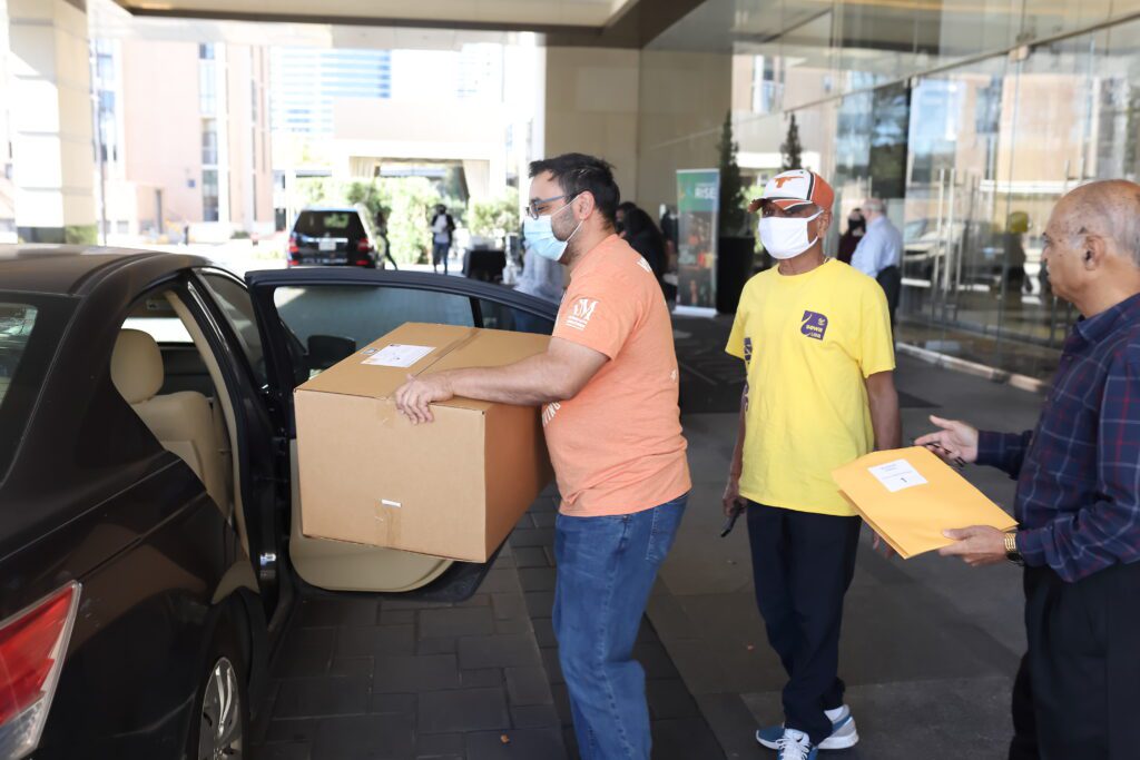Interfaith Ministries for Greater Houston volunteers load supplied into a car.