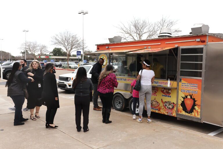 People waiting in line at a food truck.